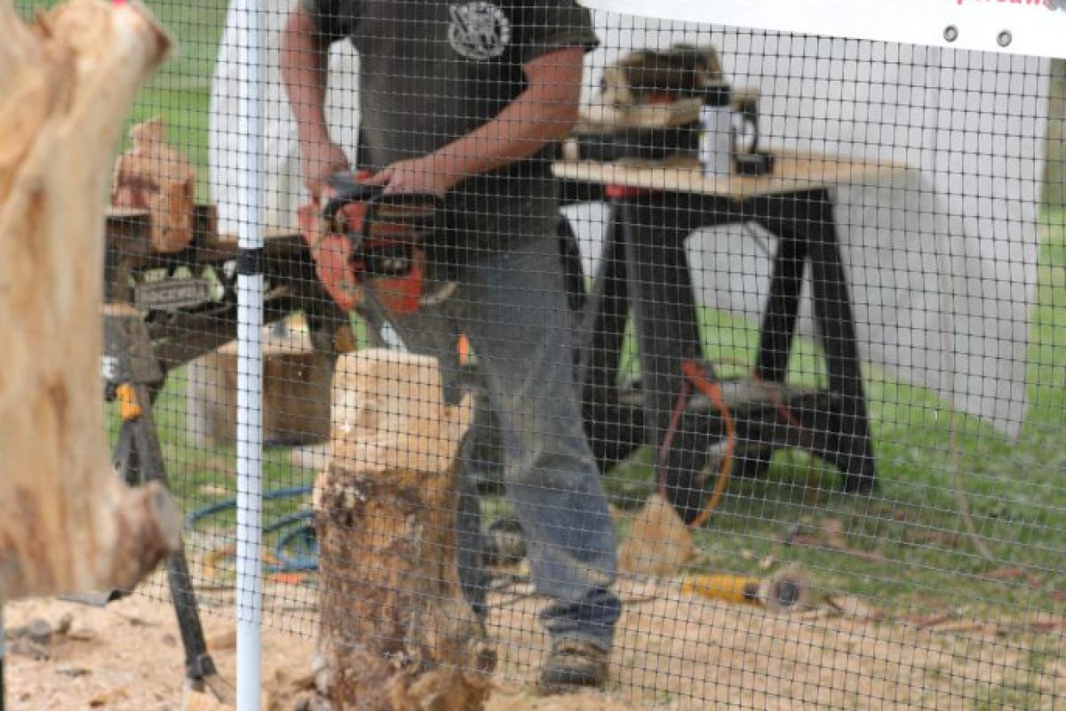 man carving wood with chainsaw